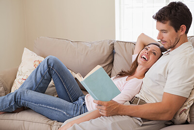 Happy couple reading on couch